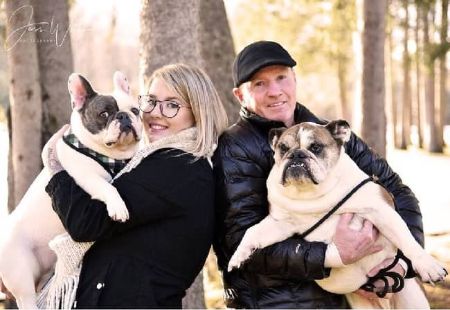 Charlene Fleming’s husband Micky and daughter Kasie posing for a photo with their pet dogs.